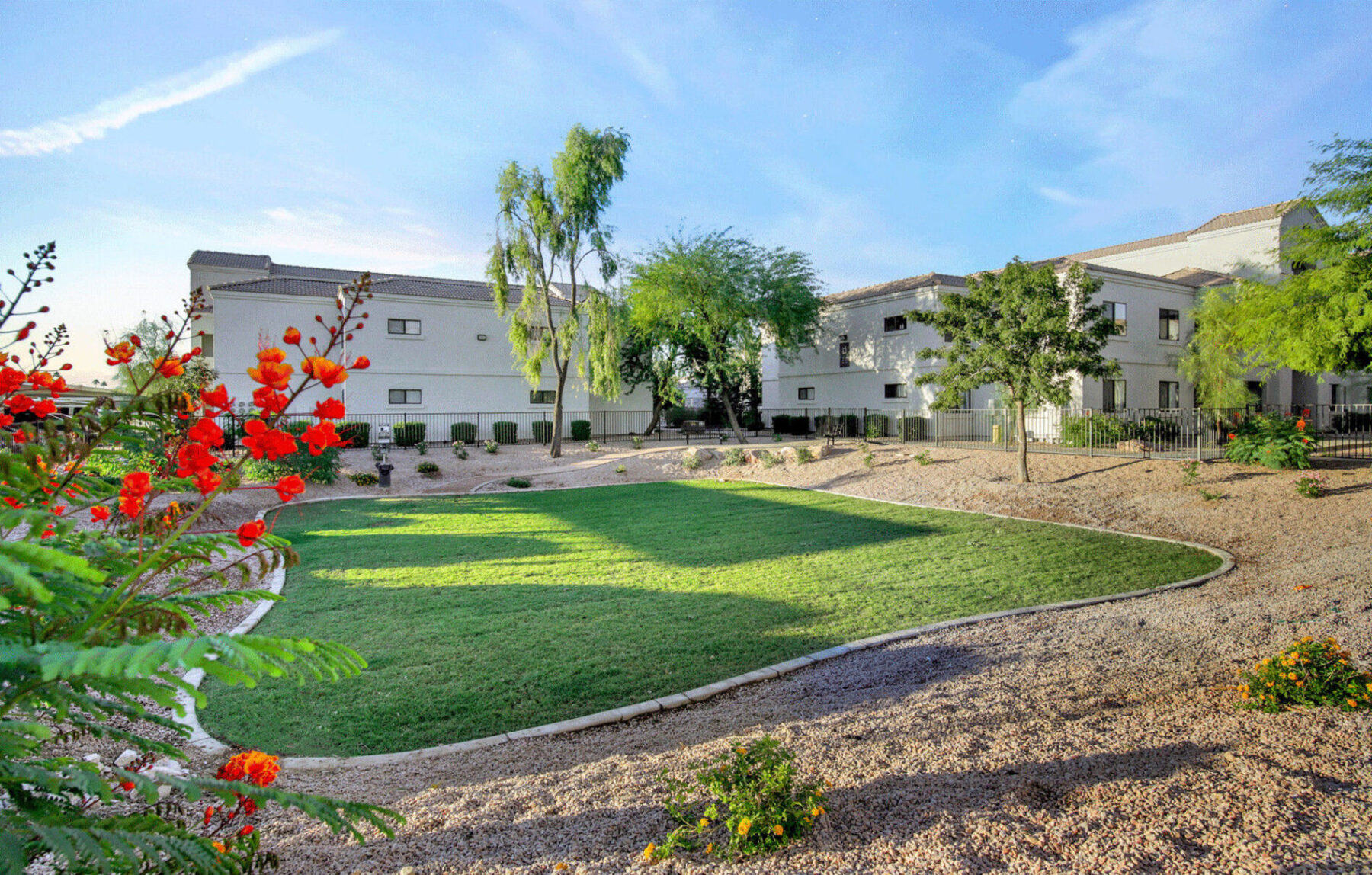 Building exterior with trees and shrubs and community green space