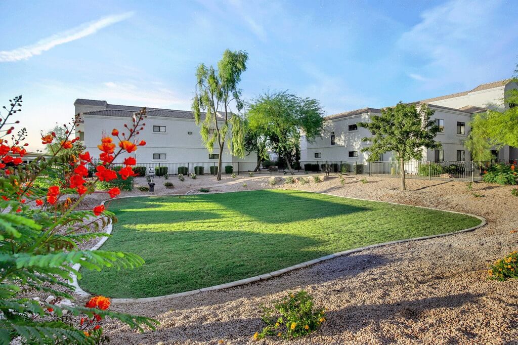 Building exterior with trees and shrubs and community green space